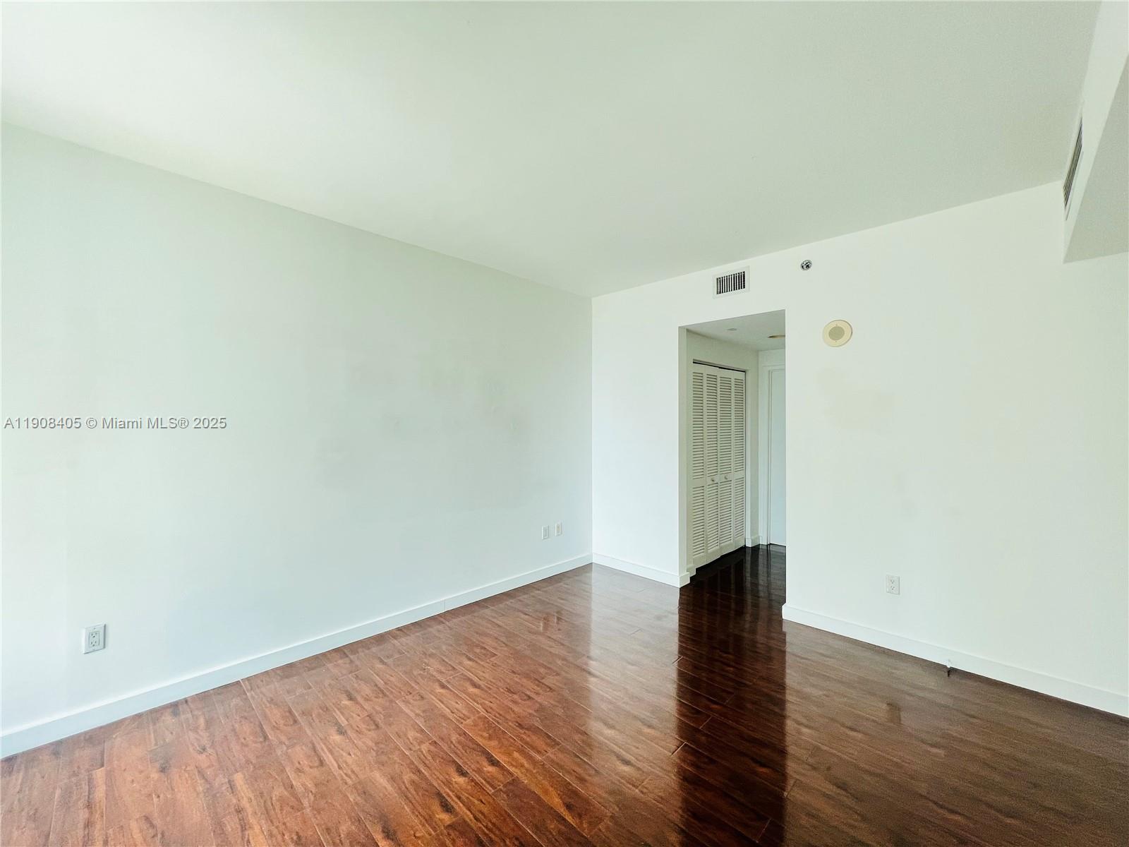 951 Brickell Avenue, Unit 2407 Miami, FL 33131 - Photo 11 of 19 an empty room with wooden floor