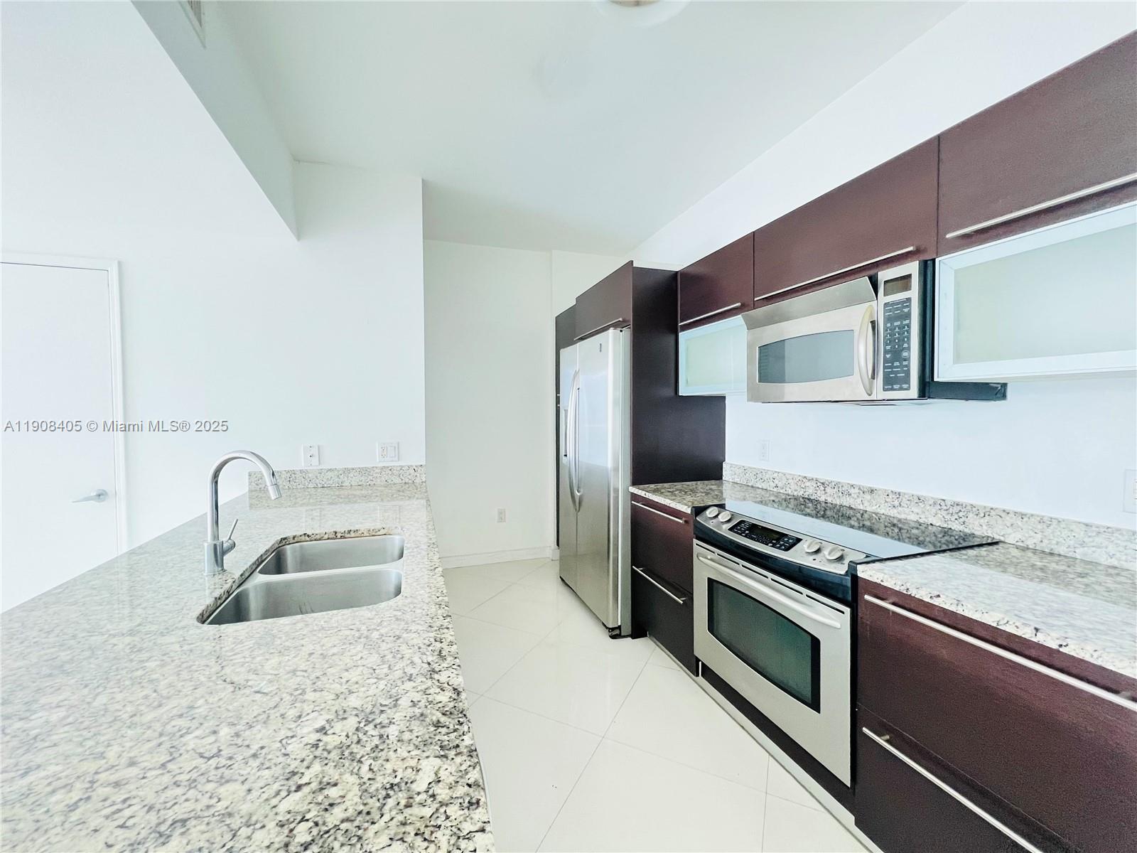 951 Brickell Avenue, Unit 2407 Miami, FL 33131 - Photo 7 of 19 a kitchen that has a sink and a stove