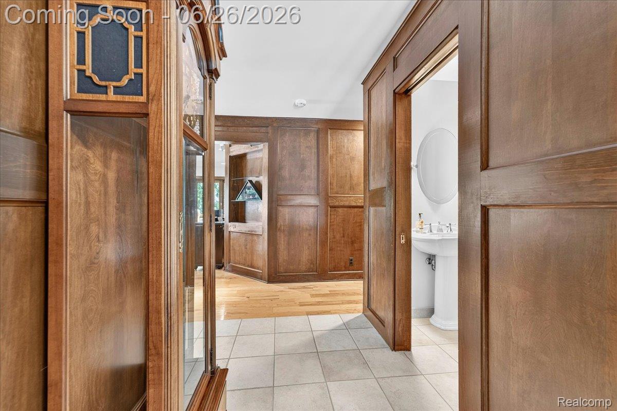 29498 East River Road Grosse Ile, MI 48138 - Photo 8 of 66 First Floor Hallway with Wood Paneled Walls and Floors ~ View of Half Bath