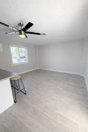 an empty room with windows and ceiling fan