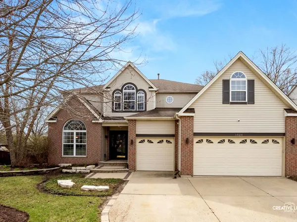 a front view of a house with a yard outdoor seating and garage