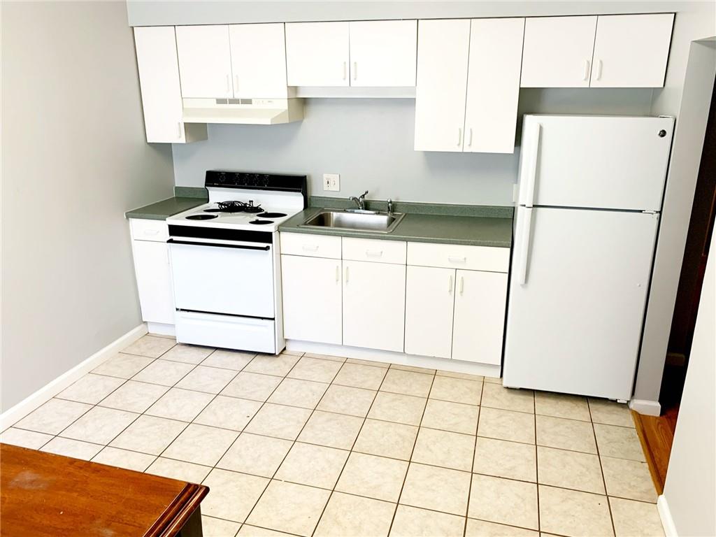 5144 Butler Street Pittsburgh, PA 15201 - Photo 11 of 20 a kitchen with cabinets and white appliances