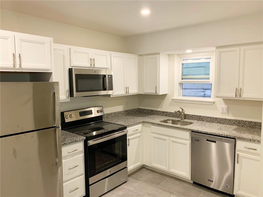 5144 Butler Street Pittsburgh, PA 15201 - Photo 13 of 20 a kitchen with granite countertop white cabinets sink and stainless steel appliances