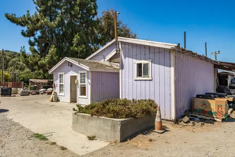 a view of a house with wooden fence