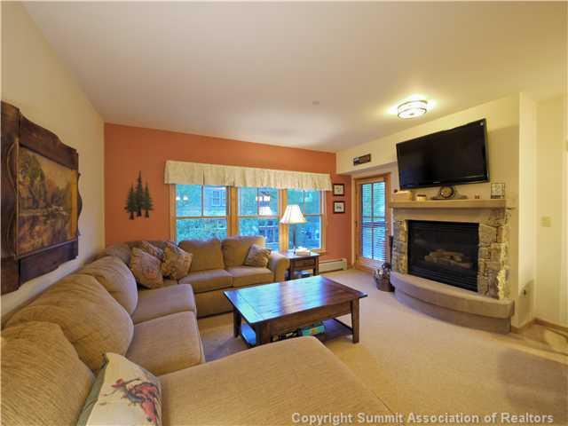 195 River Run Road, Unit 8005 Keystone, CO 80435 - Photo 2 of 12 a living room with furniture a flat screen tv and a fireplace
