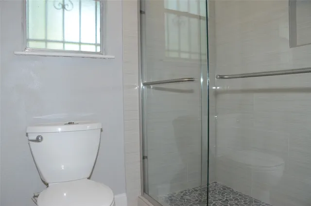 a white toilet sitting next to a window