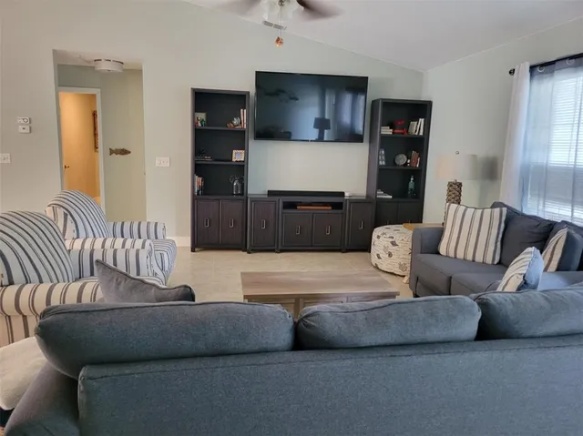 a kitchen with stainless steel appliances kitchen island granite countertop a table chairs stove and microwave