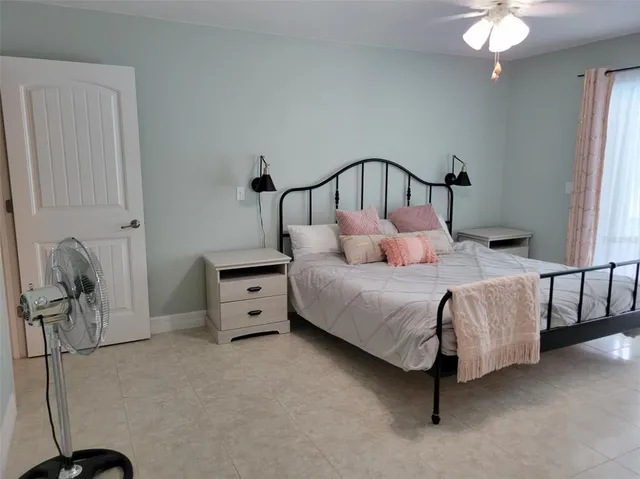 a bedroom with a bed and ceiling fan