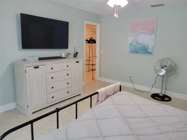 a bedroom with a bed and a lamp on dresser