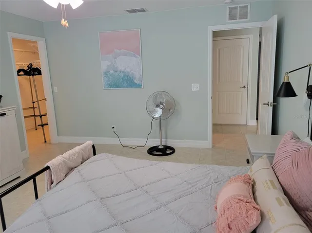 a bedroom with a bed and a lamp on desk