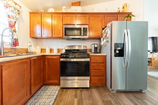 a kitchen with stainless steel appliances granite countertop a refrigerator and a stove top oven