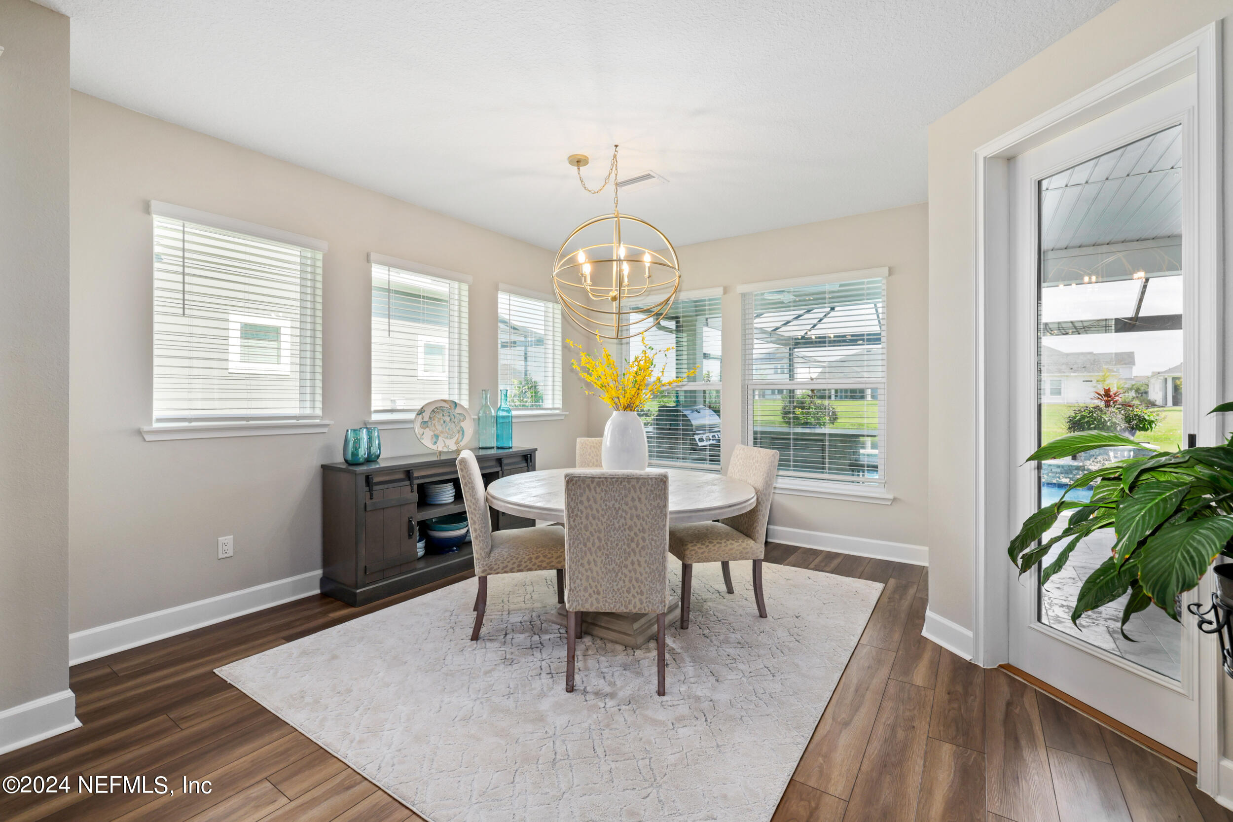 98 Sumter Pl Street St. Augustine, FL 32092 - Photo 28 of 84 a dining room with wooden floor a chandelier a wooden table and chairs