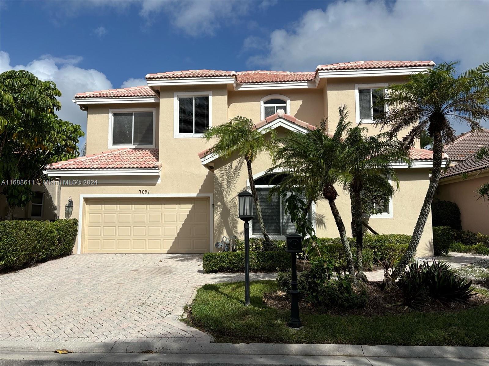 7091 Mallorca Crescent Boca Raton, FL 33433 - Photo 1 of 15 a front view of a house with a yard and garage