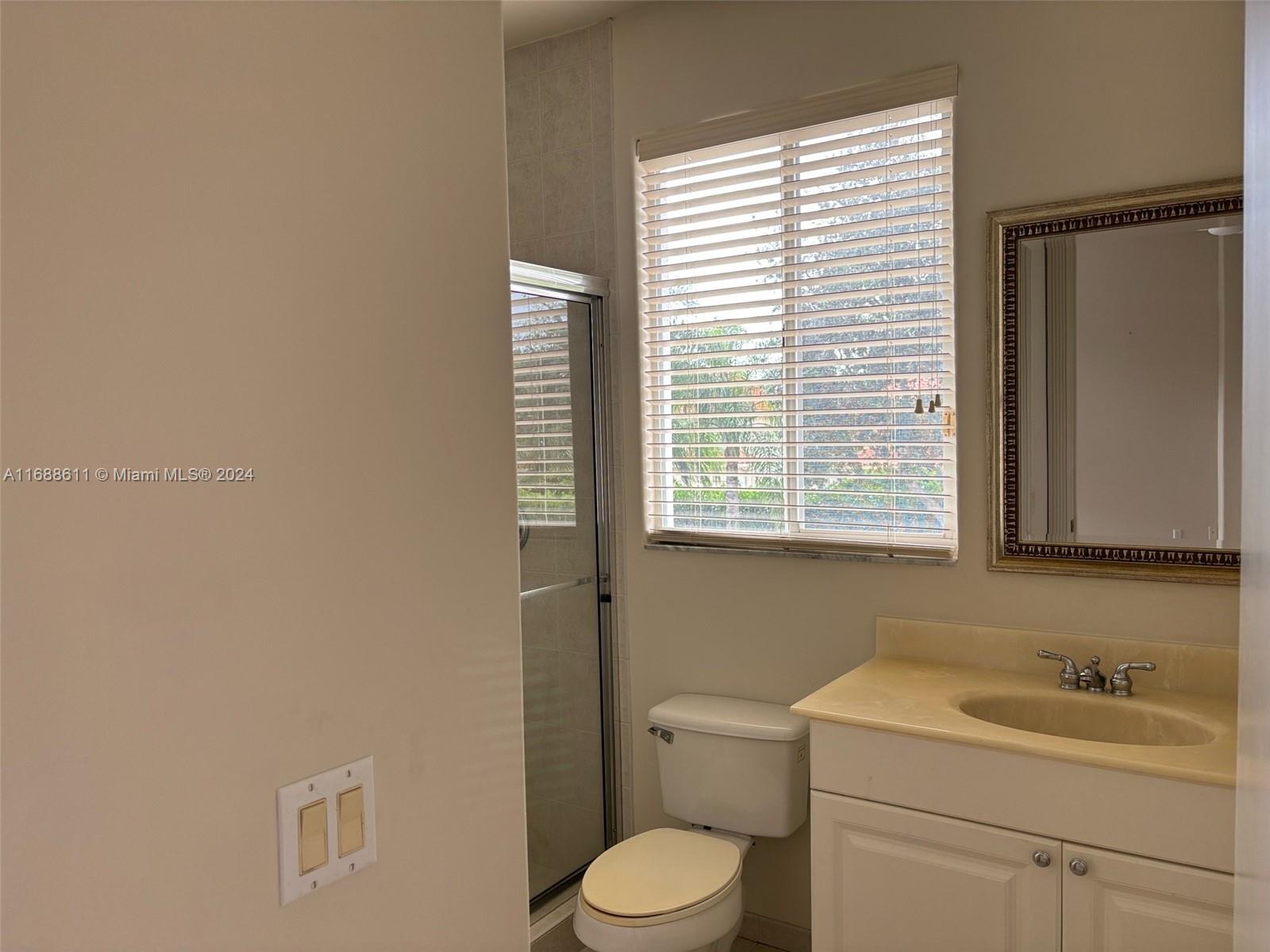 7091 Mallorca Crescent Boca Raton, FL 33433 - Photo 13 of 15 a bathroom with a toilet sink and next to a window