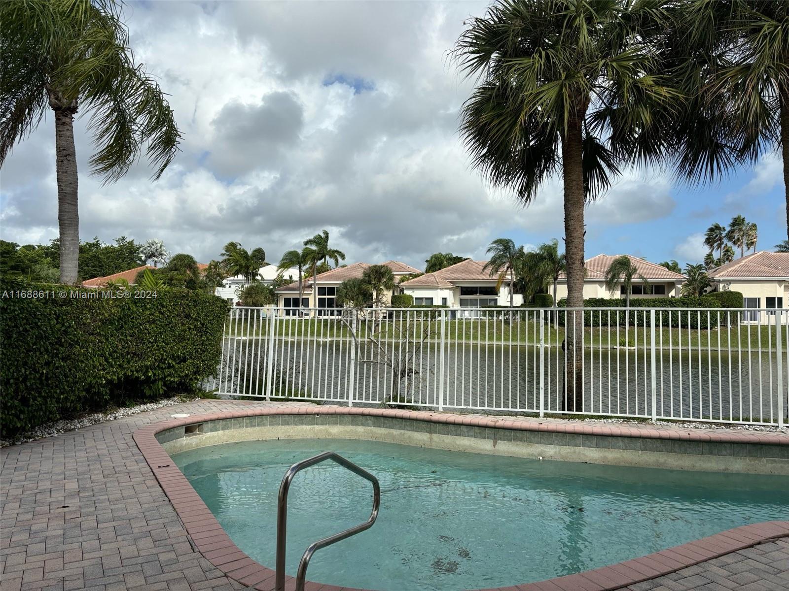 7091 Mallorca Crescent Boca Raton, FL 33433 - Photo 15 of 15 a view of a swimming pool with a garden