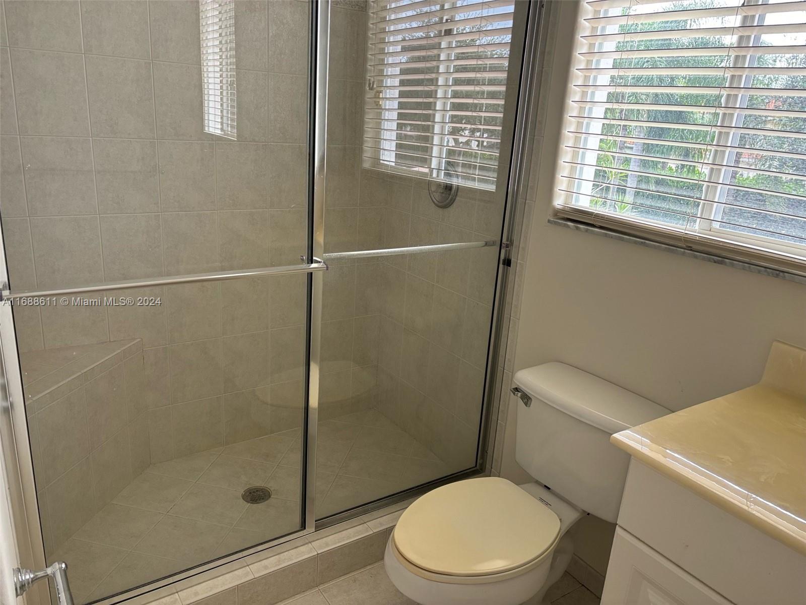7091 Mallorca Crescent Boca Raton, FL 33433 - Photo 10 of 15 a white toilet sitting next to a shower