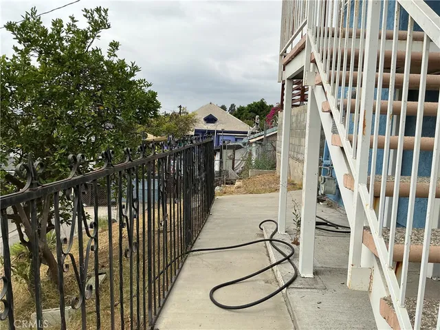 an aerial view of a house with a yard and covered with trees