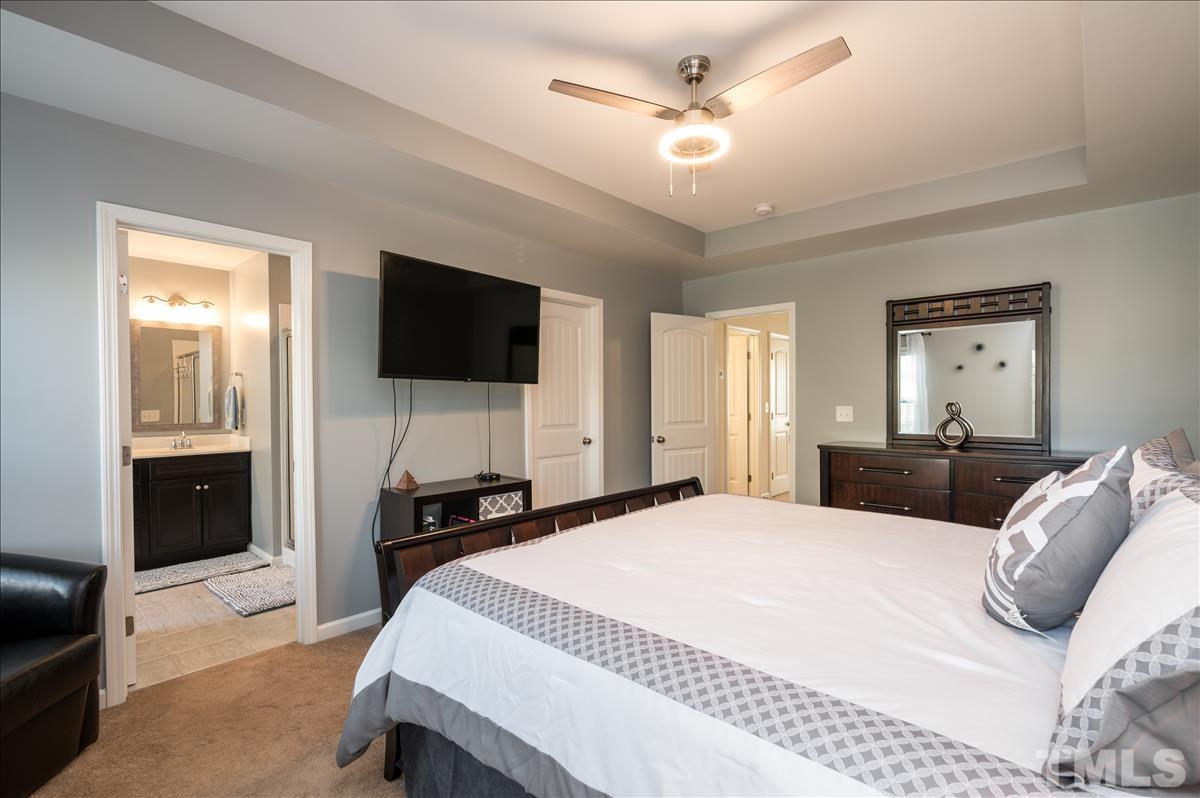 4625 Pat Reed Road Raleigh, NC 27616 - Photo 16 of 28 a bedroom with a bed and a flat tv screen on wall