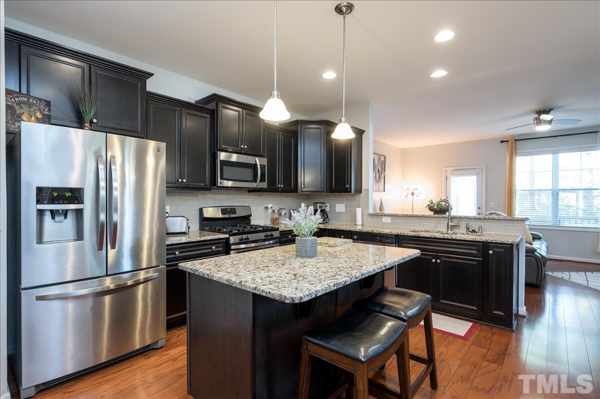 4625 Pat Reed Road Raleigh, NC 27616 - Photo 4 of 28 a kitchen with a center island appliances and cabinets