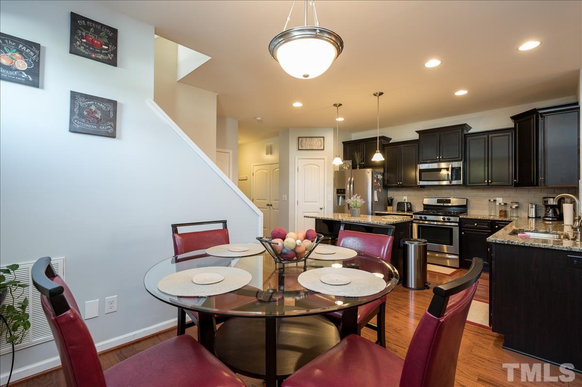 4625 Pat Reed Road Raleigh, NC 27616 - Photo 8 of 28 a kitchen with stainless steel appliances kitchen island granite countertop a sink a stove a kitchen island with chairs dining table and chairs