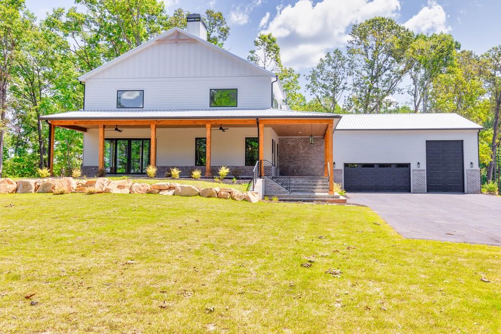 a front view of house with yard and trees in the background