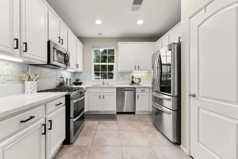 a kitchen with stainless steel appliances granite countertop a refrigerator sink and stove