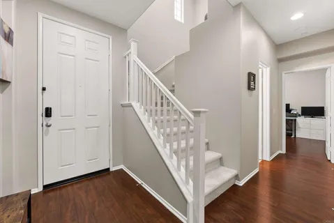 a view of a hallway with wooden floor and staircase