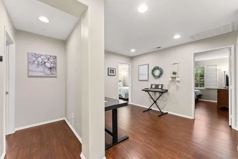 a view of a hallway with wooden floor and furniture