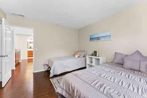 a bedroom with two beds and wooden floor