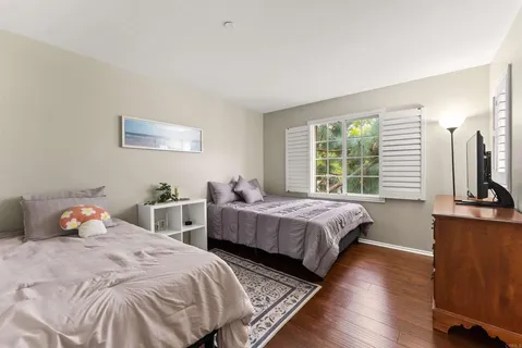 a bedroom with two beds and a large window