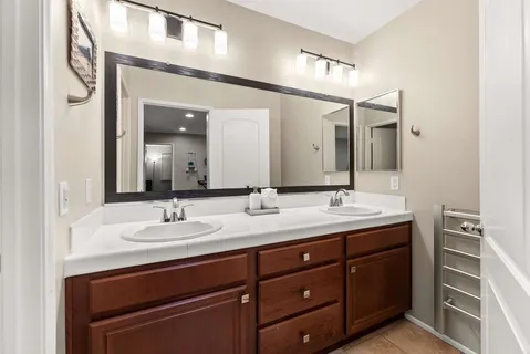 a bathroom with a double vanity sink and a mirror