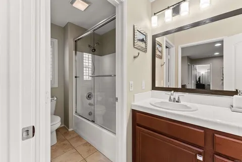 a bathroom with a shower sink and mirror