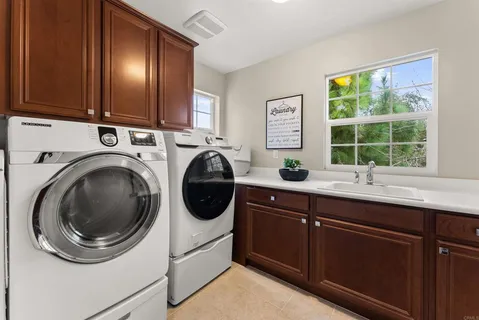 a utility room with sink dryer and washer