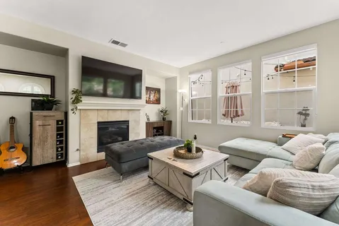 a living room with furniture a flat screen tv and a fireplace