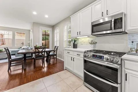 a kitchen with a stove a microwave and living room