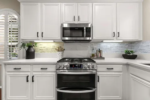 a kitchen with stainless steel appliances granite countertop white cabinets and a stove