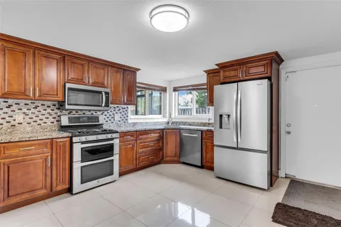 a kitchen with stainless steel appliances granite countertop a stove sink and cabinets