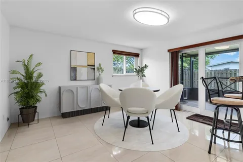 an empty room with chandelier fan and windows