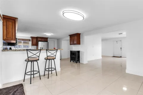 a kitchen with granite countertop stainless steel appliances a refrigerator a stove a sink cabinets and a window