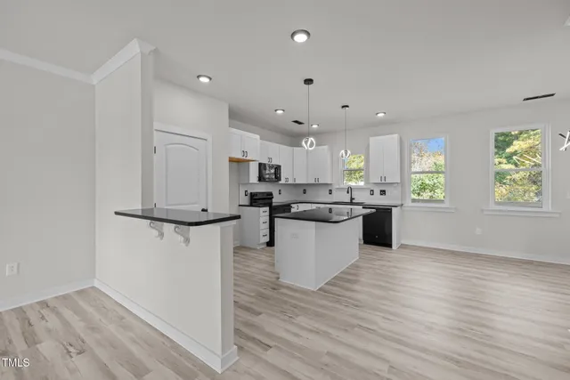 a large kitchen with a lot of counter top space and stainless steel appliances