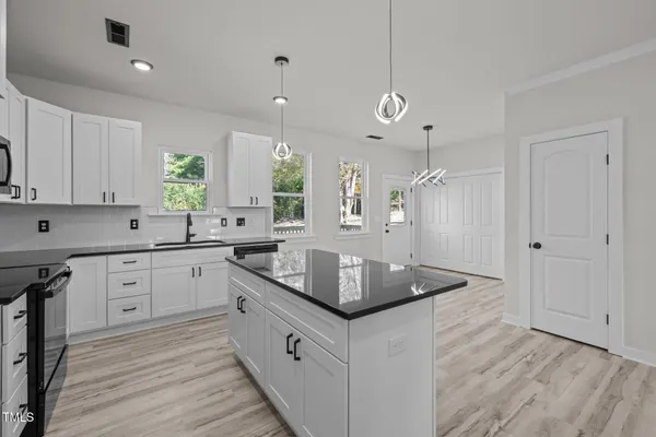 a kitchen with stainless steel appliances granite countertop a sink a stove and a refrigerator