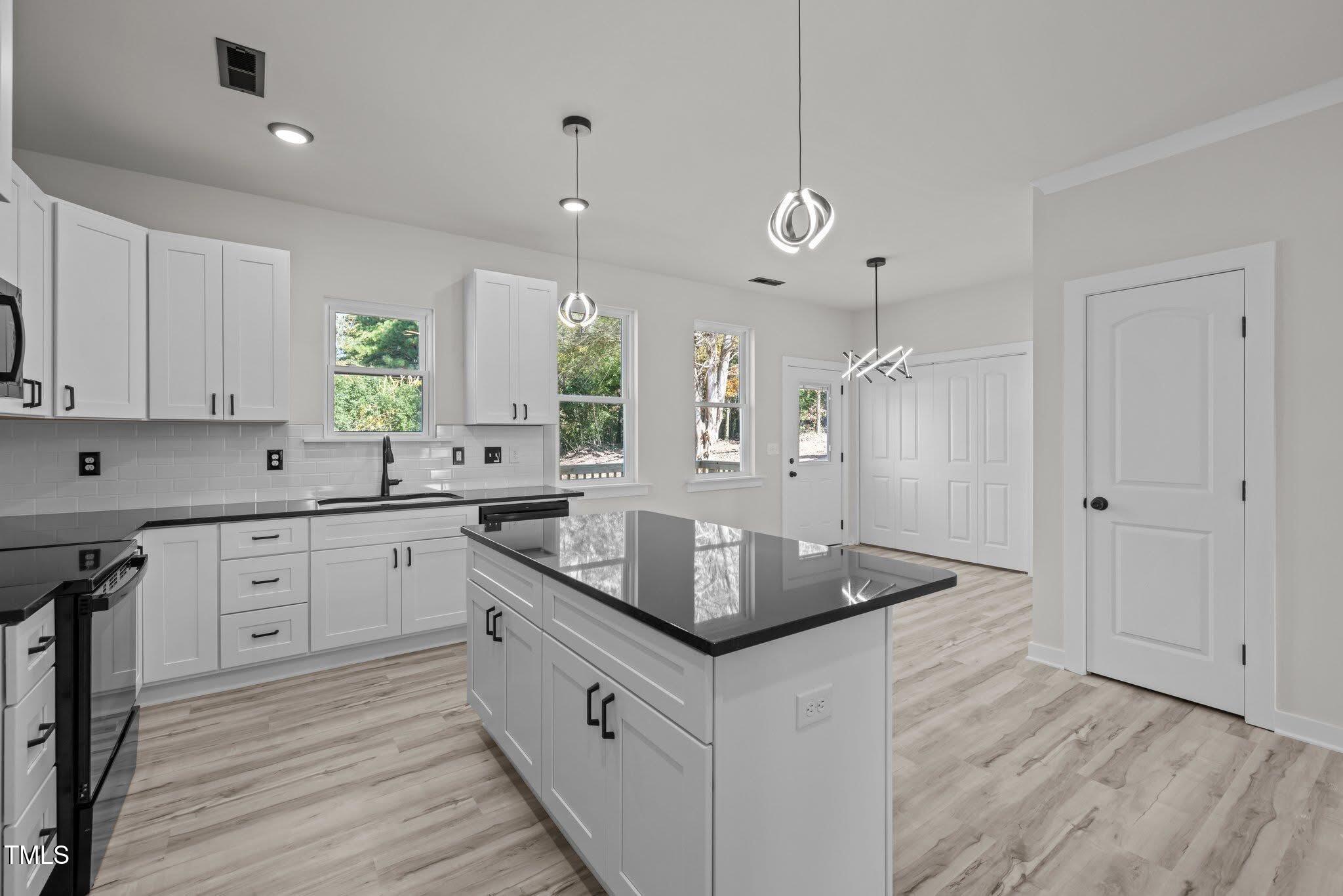 2015 Cheek Road Durham, NC 27704 - Photo 4 of 12 a kitchen with stainless steel appliances granite countertop a sink a stove and a refrigerator