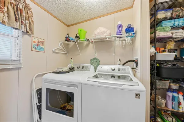 a utility room with dryer washer and a view of living room