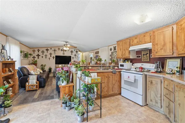 a kitchen with stainless steel appliances kitchen island granite countertop a table chairs in it and a window