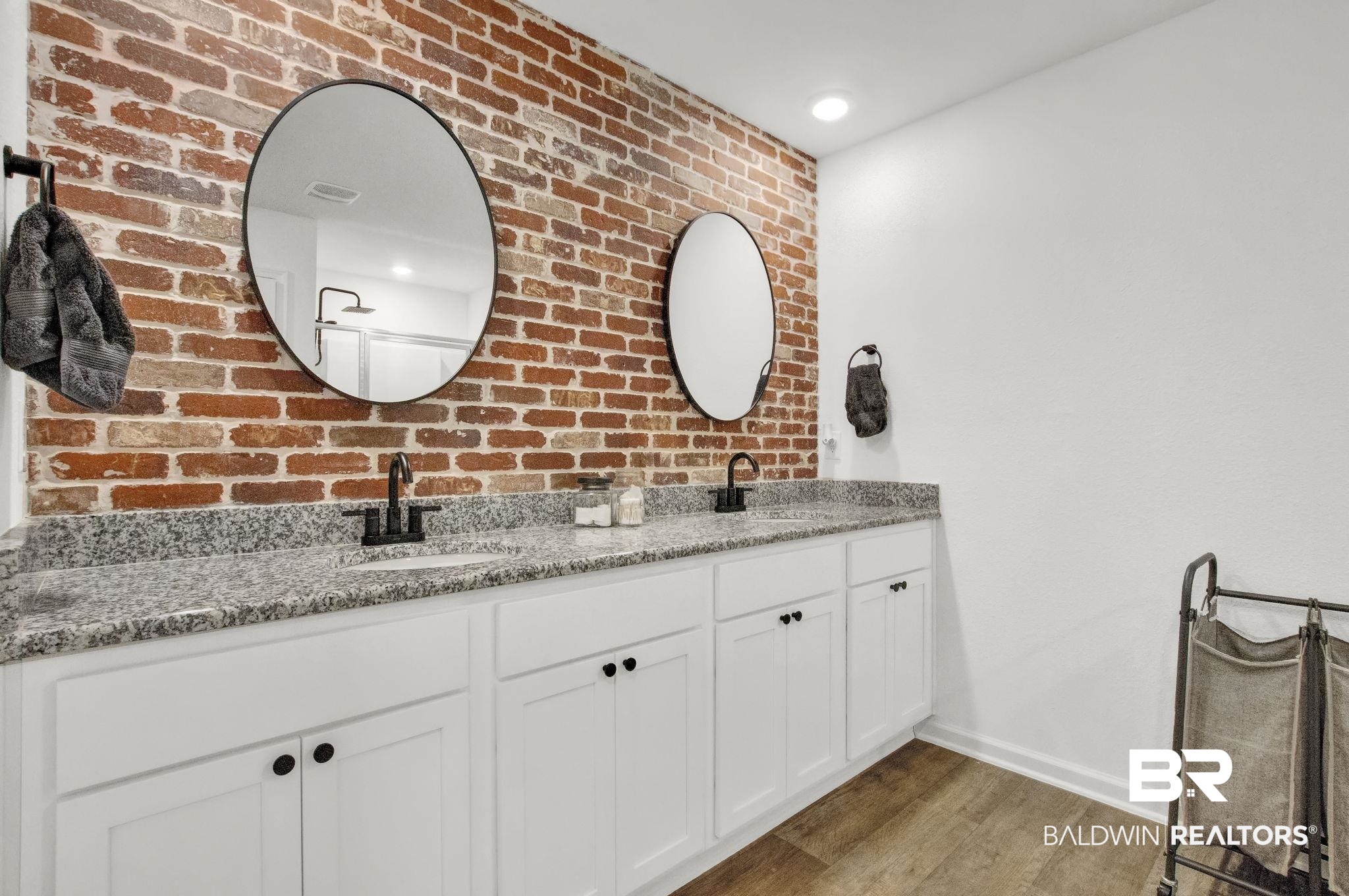 23810 Unbridled Loop Daphne, AL 36526 - Photo 19 of 50 Bathroom featuring brick wall, vanity, and hardwood / wood-style flooring