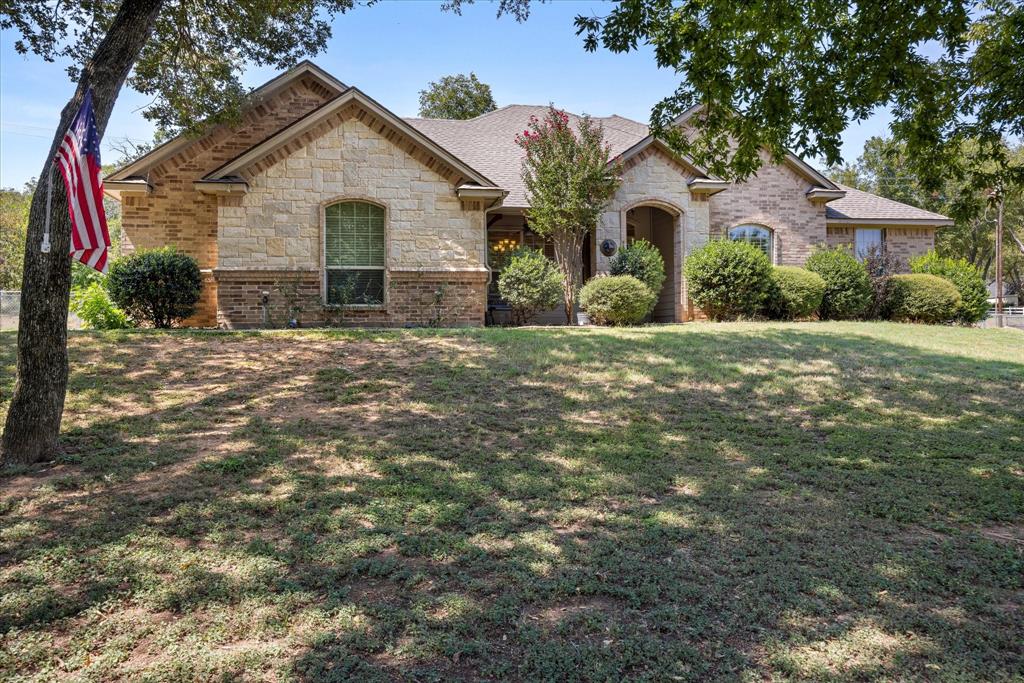 7707 Ravenswood Road Granbury, TX 76049 - Photo 1 of 1 a front view of a house with garden