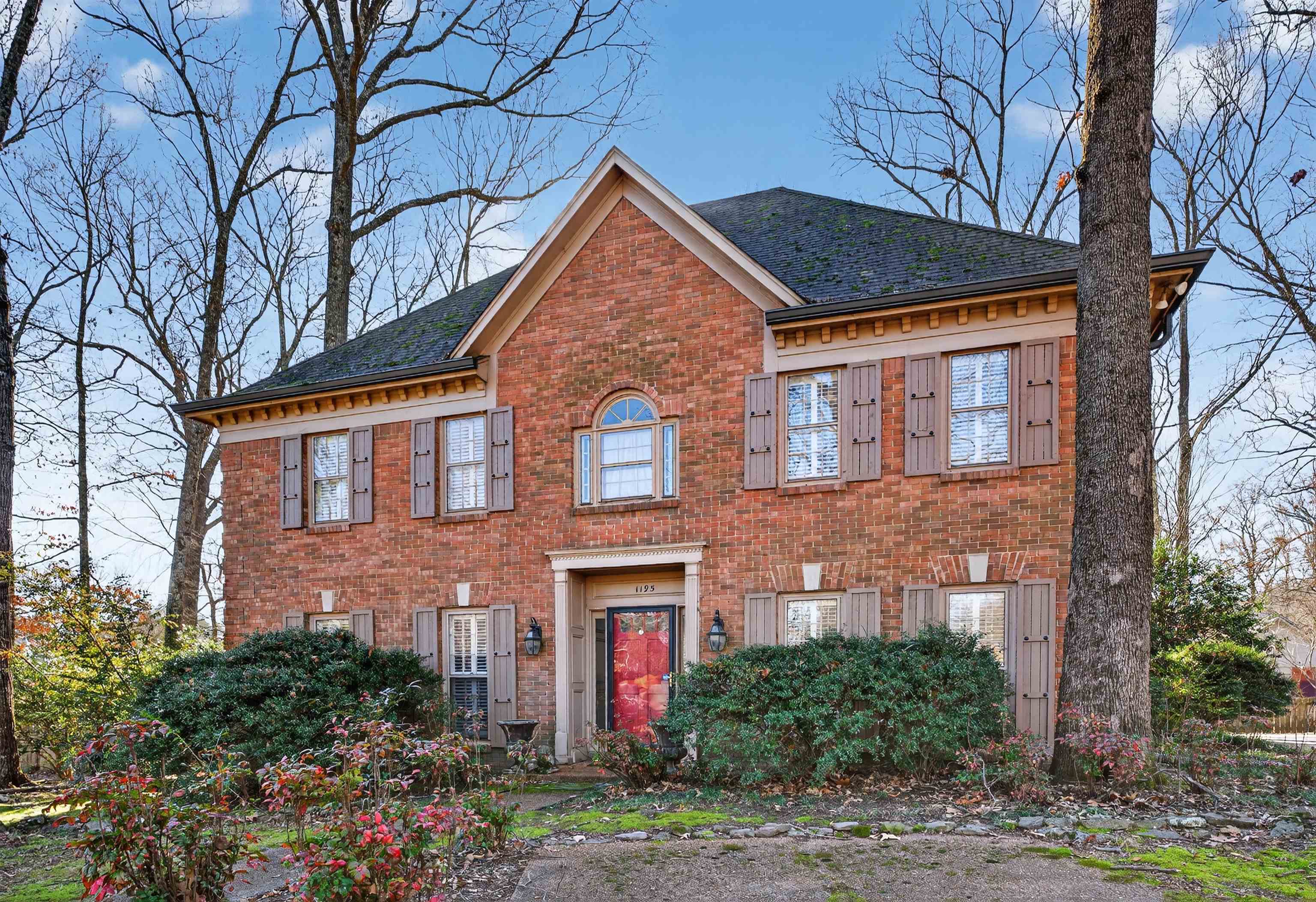 View of front of house with brick siding and roof with shingles
