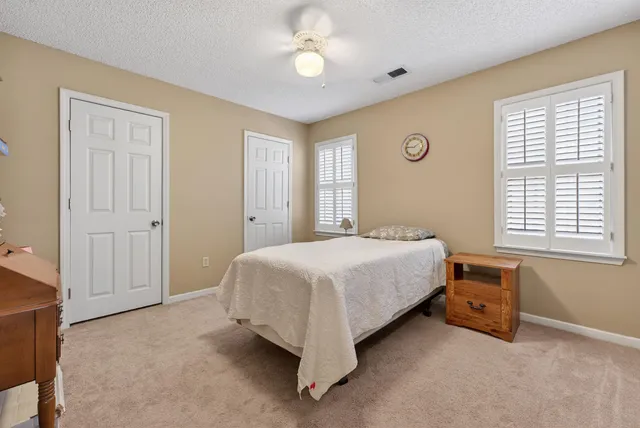 a spacious bedroom with a bed and a chandelier