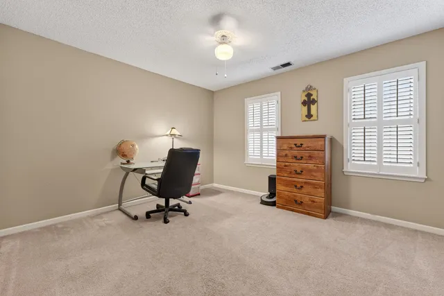 a view of a workspace with furniture and a window