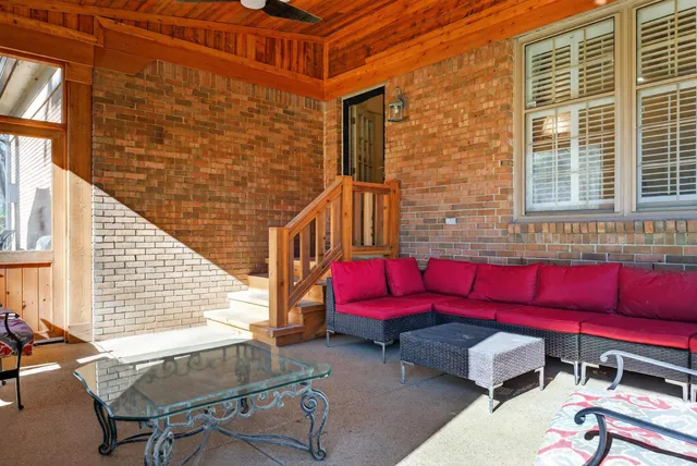 a red brick building with red door and chair